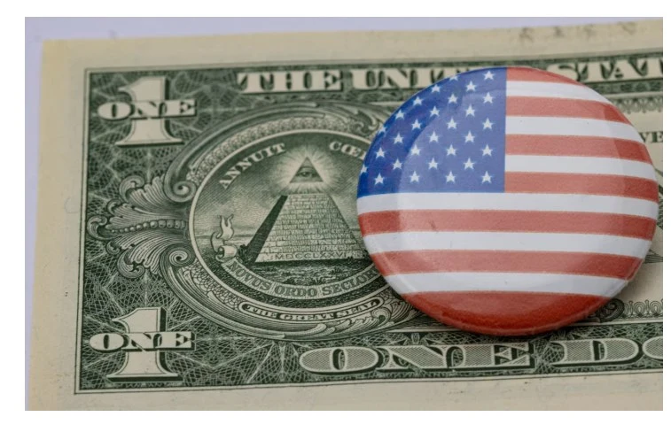 U.S. dollar bill with an American flag pin